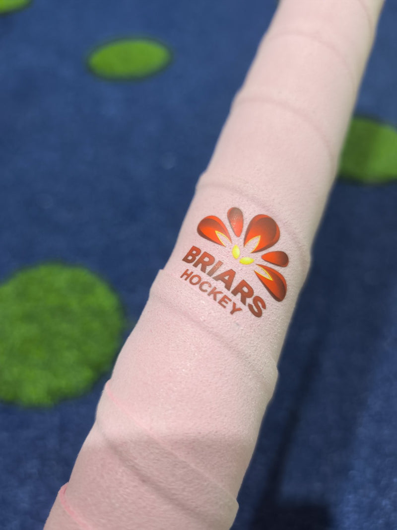 Briars Hockey crest on a pink Griptonyte grip, on a stick, on blue turf