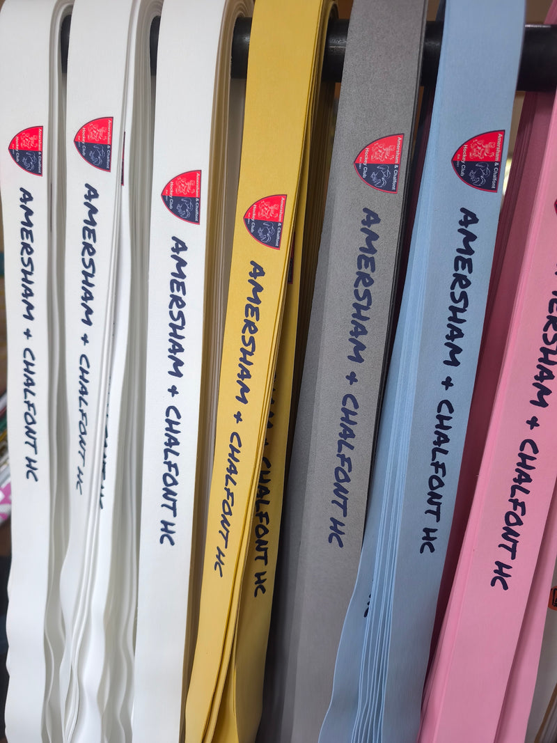 Amersham & Chalfont Hockey Club crest and name on a set of coloured Griptonyte grips