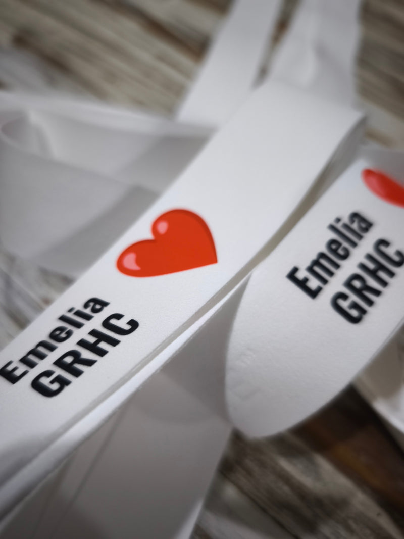 A red heart, a name and a club tag printed on white custom Griptonyte grips